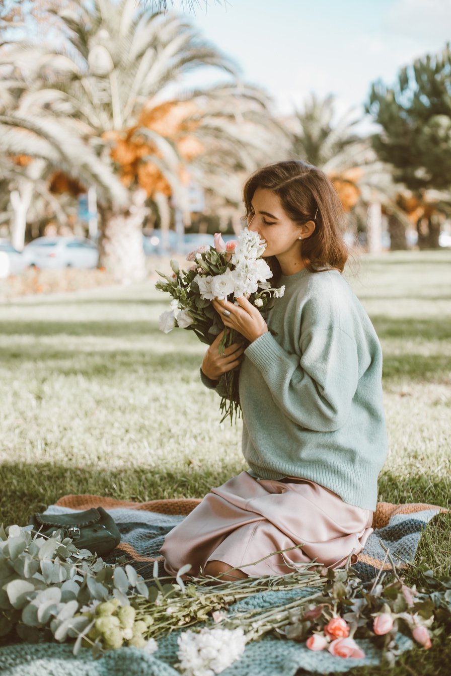 Woman in Green Sweater Sitting on Green Grass Field